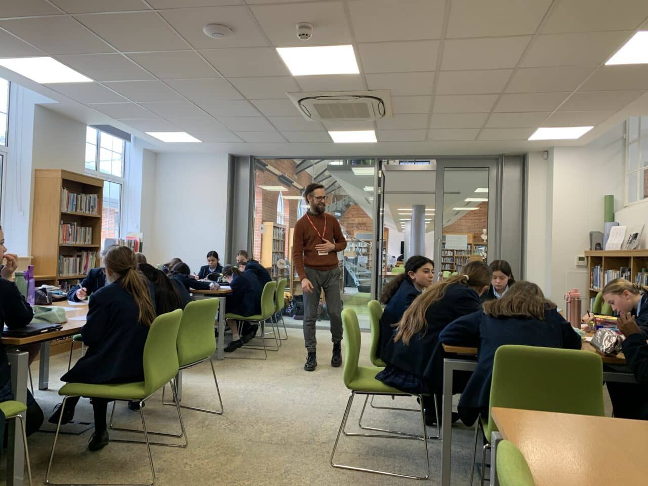 Dan leading a creative writing session with secondary school students in a library